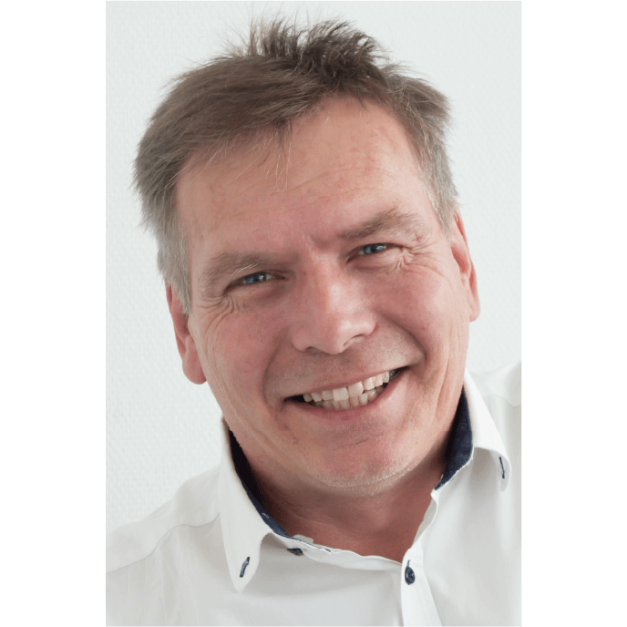 Ein Mann lächelt freundlich in die Kamera, bereit für seinen nächsten Arbeitseinsatz. Im Hintergrund ist nichts Ablenkendes.